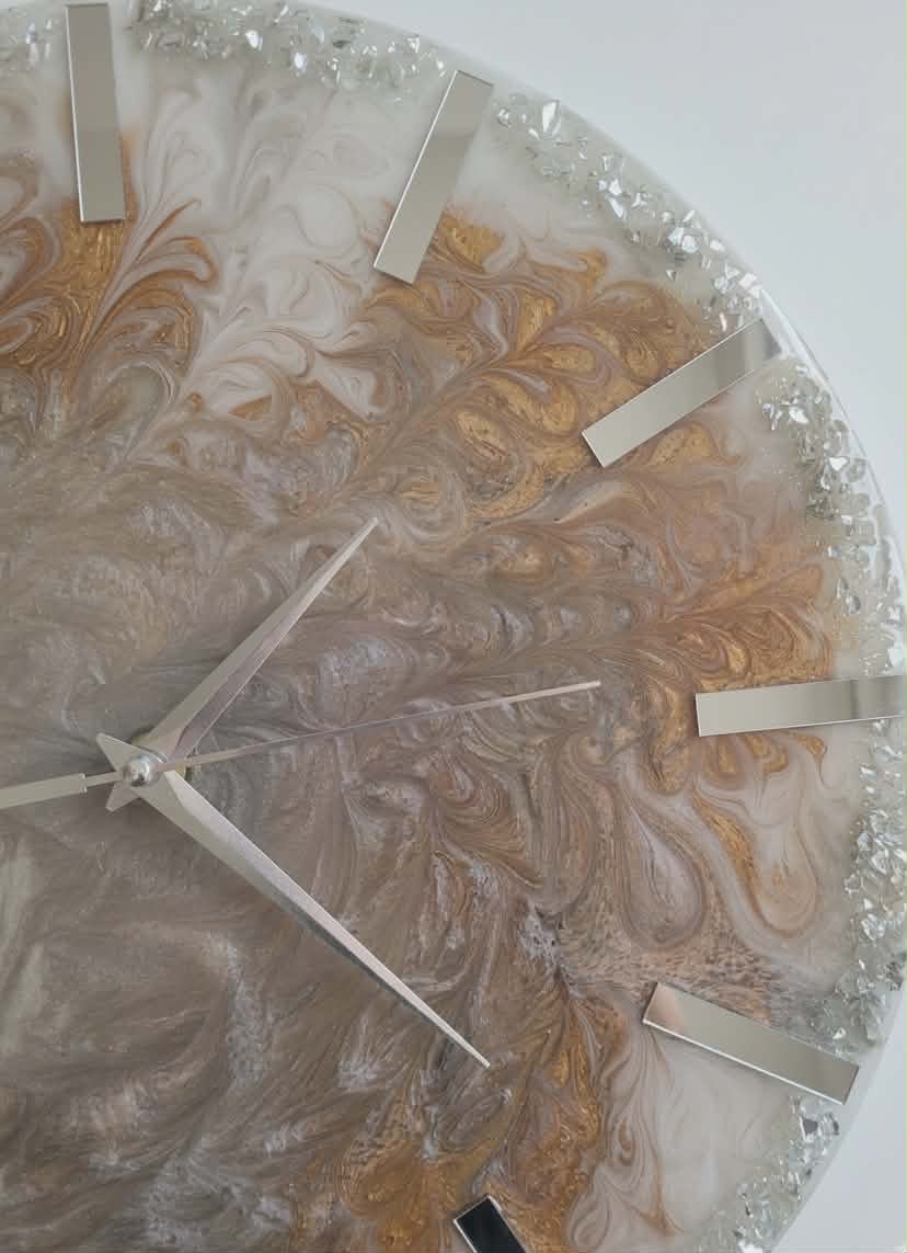 Decorative wall clock with marble-like design and gold accents on a white background