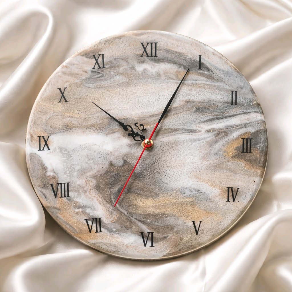 Marble-patterned wall clock with Roman numerals on a white fabric background