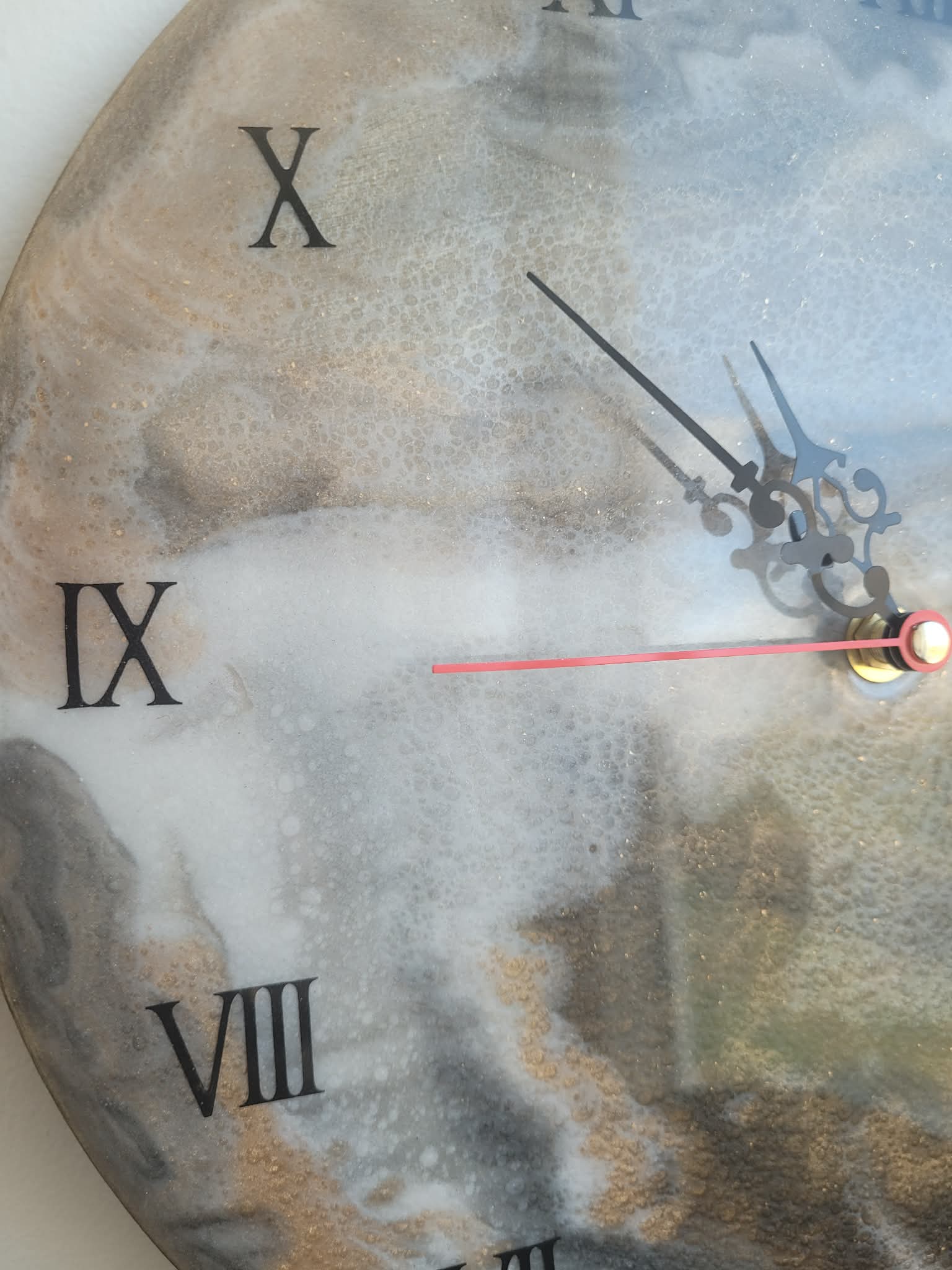 Close-up of a clock face with Roman numerals and a sword-like hand.