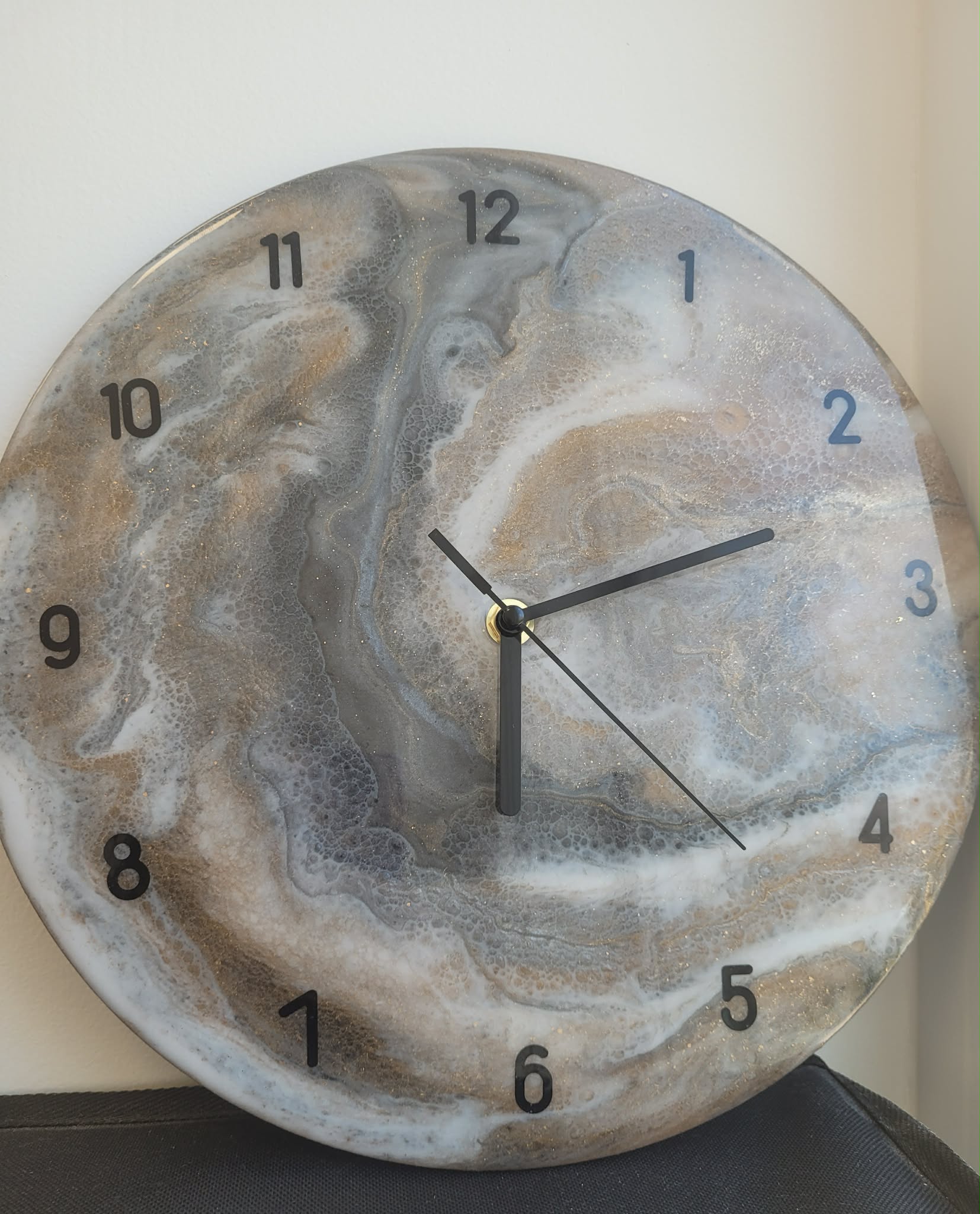 Round wall clock with a marbled design on a plain background