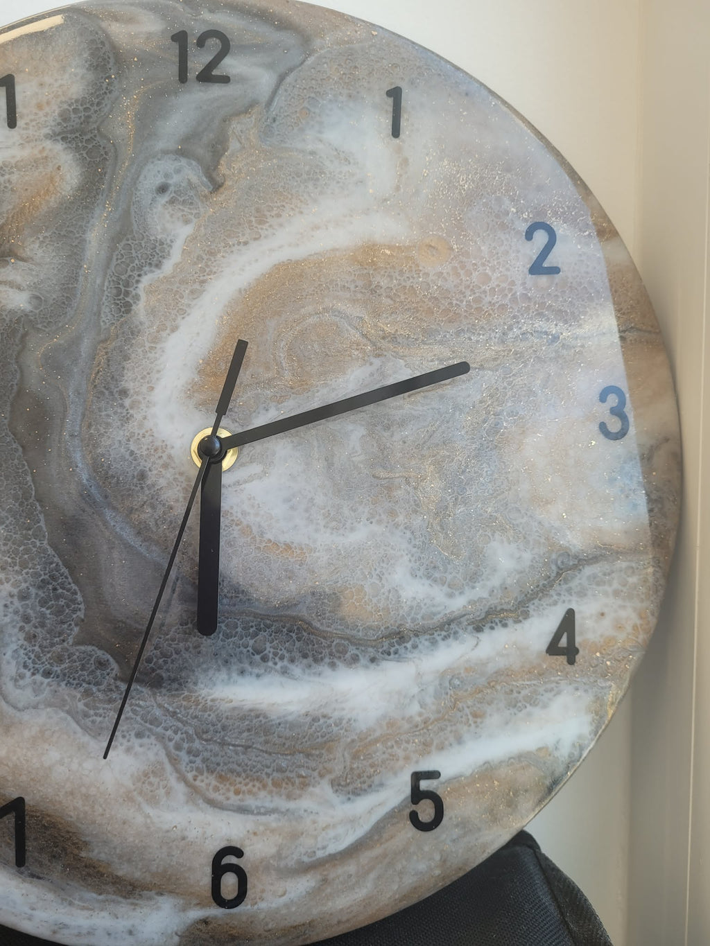 Marble-patterned clock with black hands on a neutral background