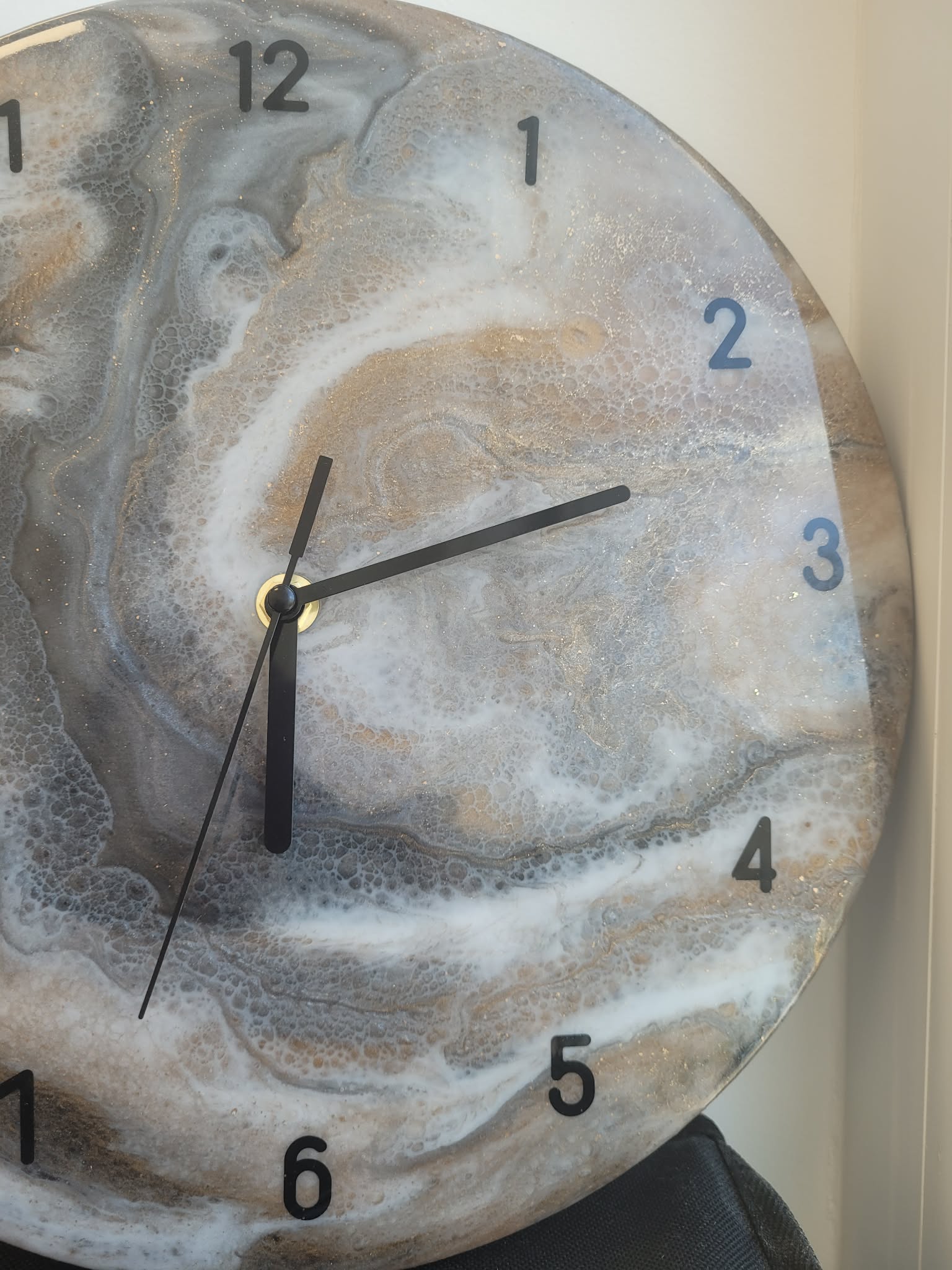 Marble-patterned clock with black hands on a neutral background