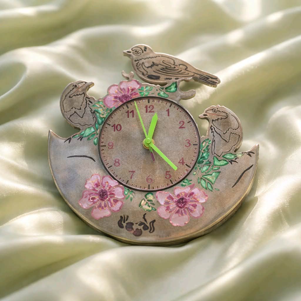 Decorative clock with birds and flowers on a soft fabric background