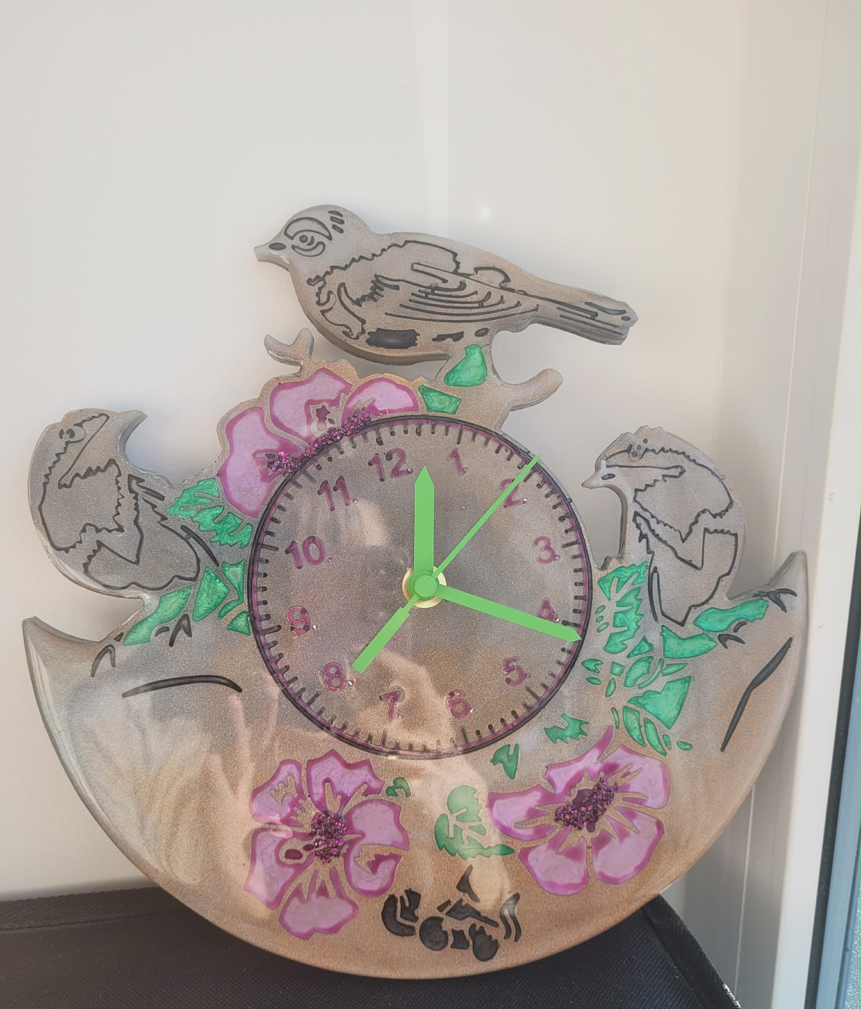 Decorative wall clock with floral and bird designs on a white background