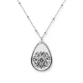 Teardrop-shaped silver pendant with floral design on a white background