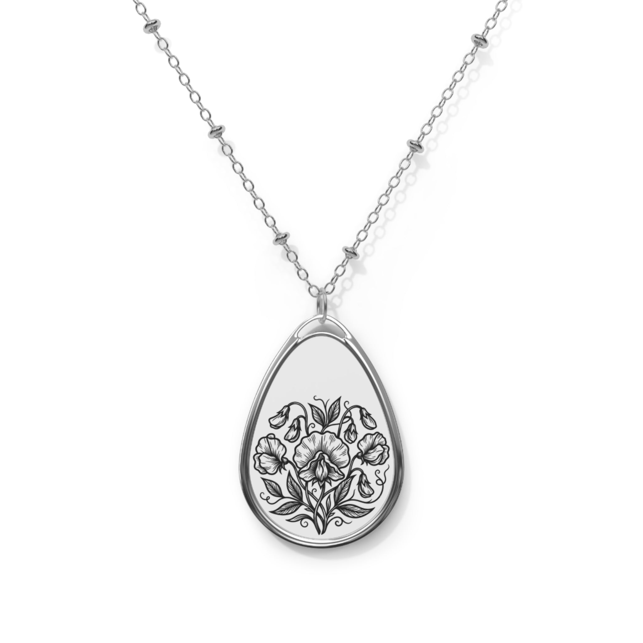 Teardrop-shaped silver pendant with floral design on a white background