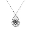 Teardrop-shaped pendant with floral design on a chain against a white background