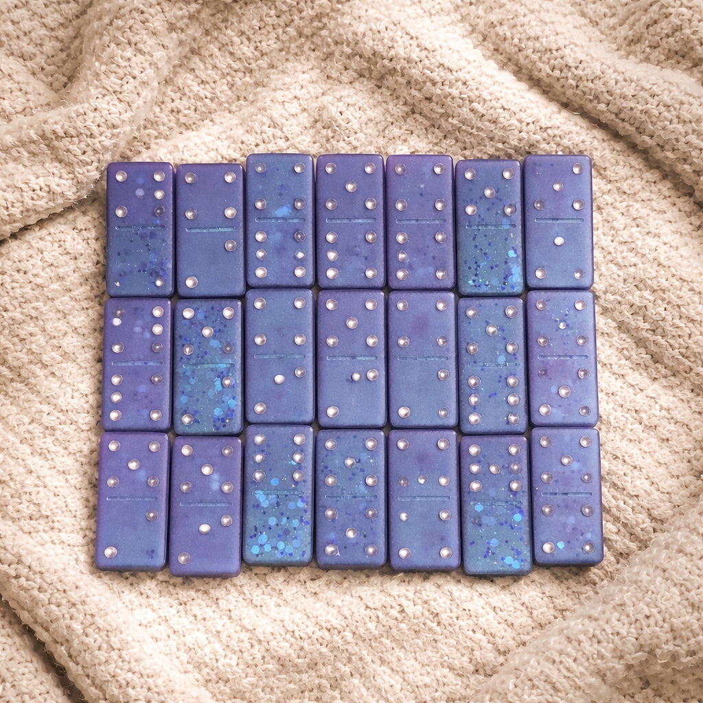Set of blue dominoes arranged in a grid on a textured beige surface