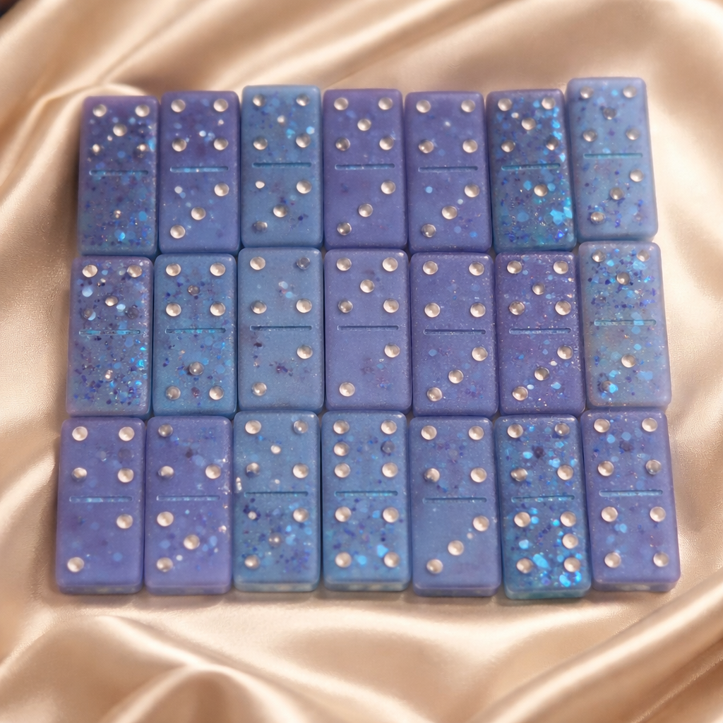 Set of blue dominoes with glittery texture on a beige fabric background