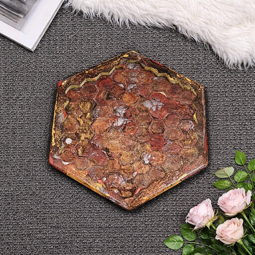 Hexagonal decorative stone on a textured surface with flowers and a book in the background