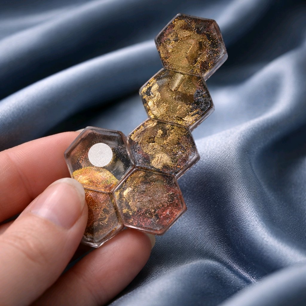 Hexagonal crystal-like object held by a hand on a blue fabric background