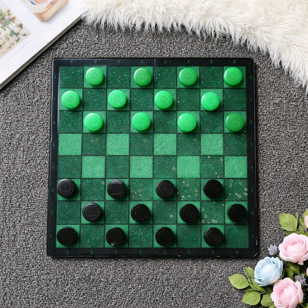 Checkers board with green and black pieces on a textured surface with flowers.