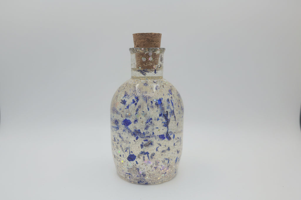 Decorative bottle with blue speckles on a white background