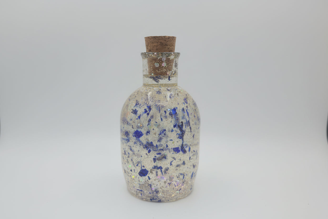 Decorative bottle with blue speckles on a white background