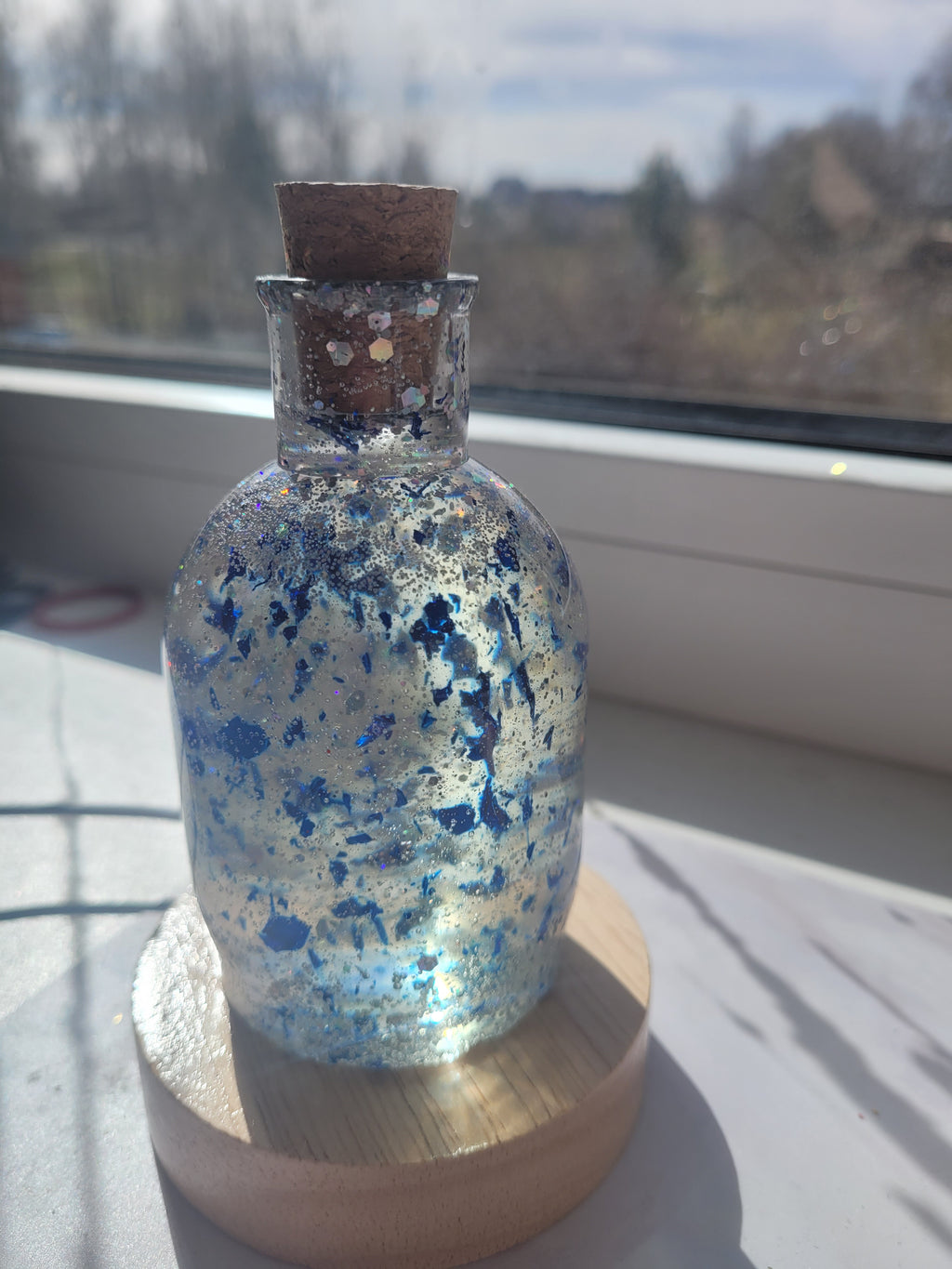 Decorative bottle with blue speckles on a wooden surface