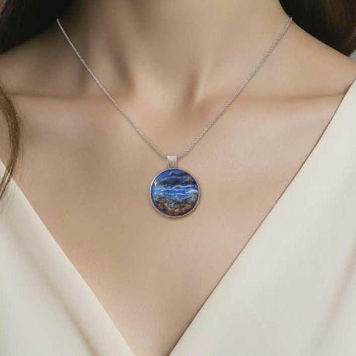 Necklace with a blue pendant on a person wearing a white top