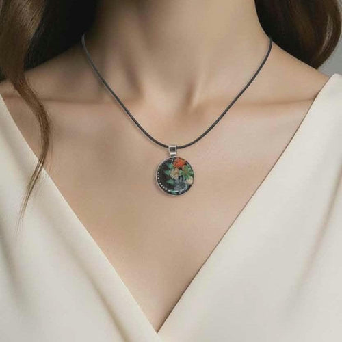 Necklace with a floral pendant worn by a person in a white outfit