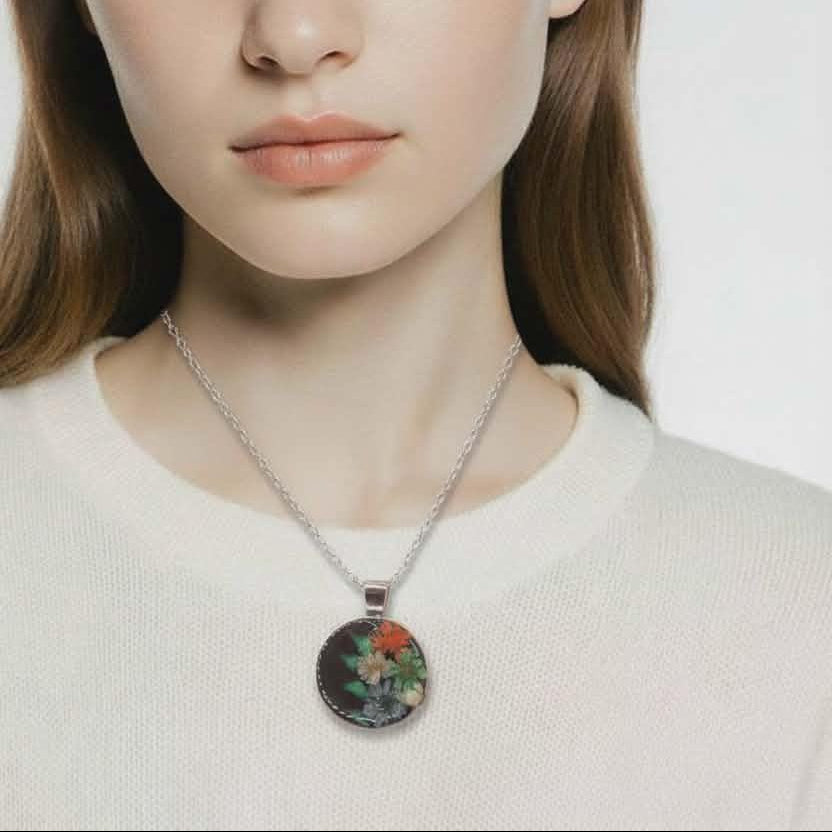 Woman wearing a necklace with a floral pendant against a plain background