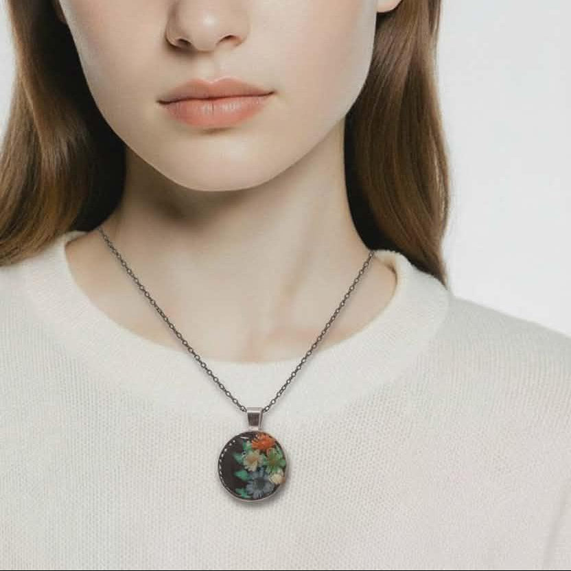 Woman wearing a necklace with a floral pendant against a plain background