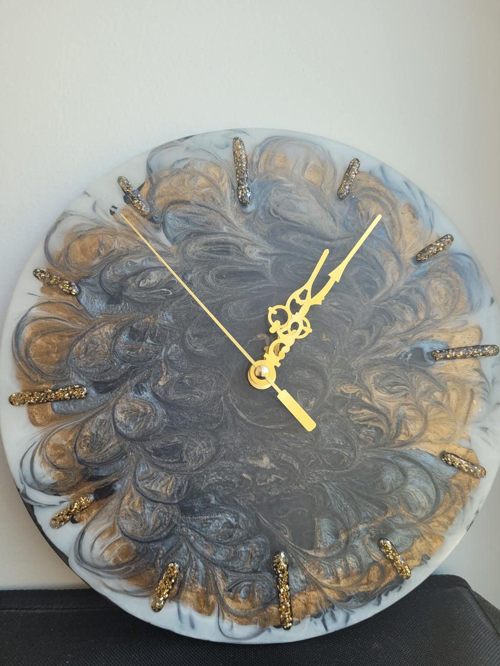 Decorative wall clock with gold accents on a white background