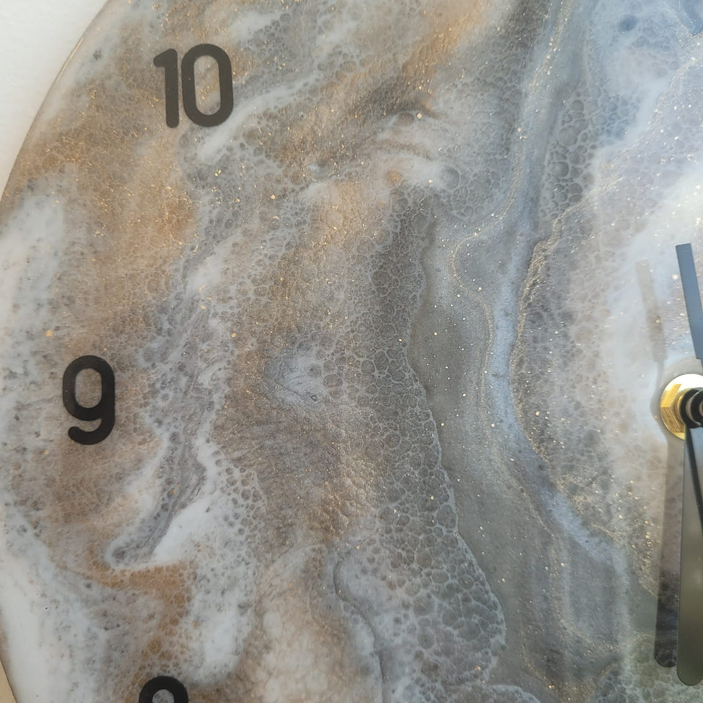Marble-patterned clock with gold accents on a white background