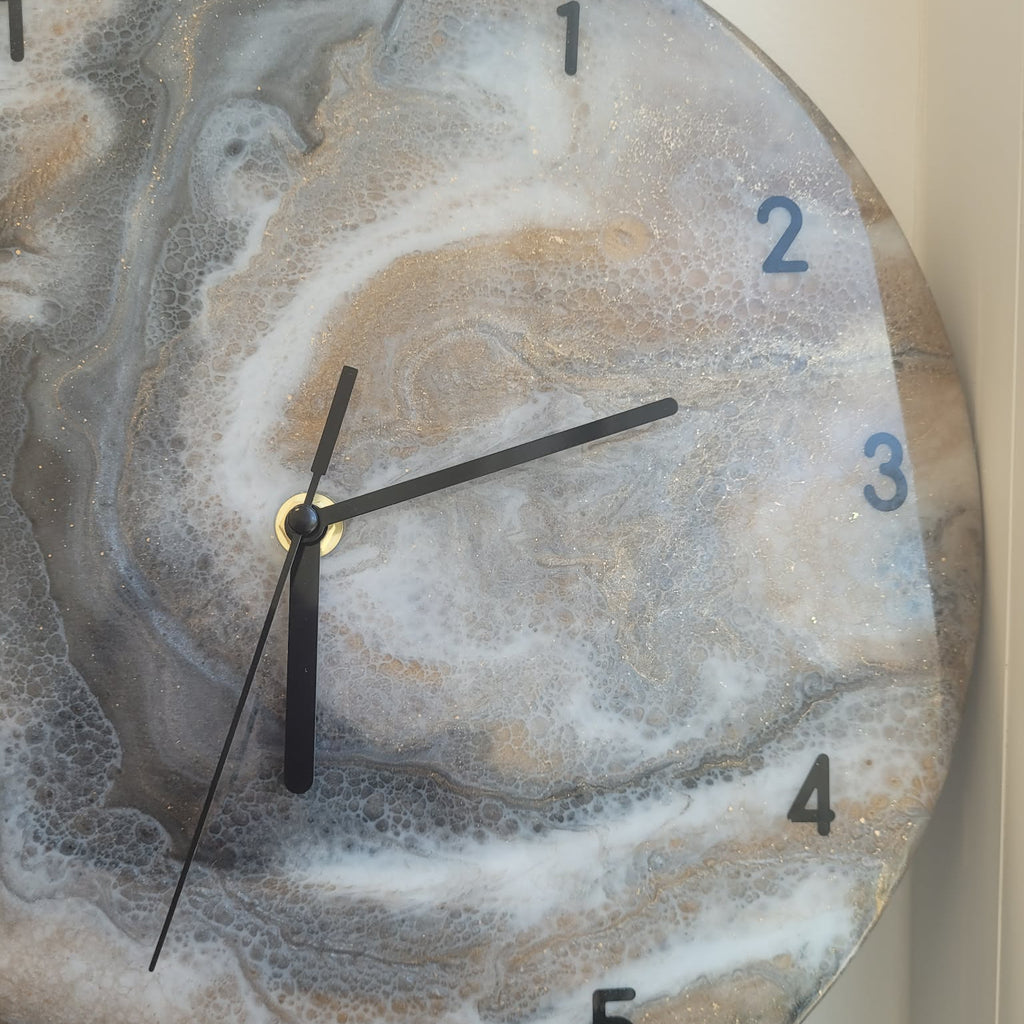 Marble-patterned clock with black hands on a neutral background