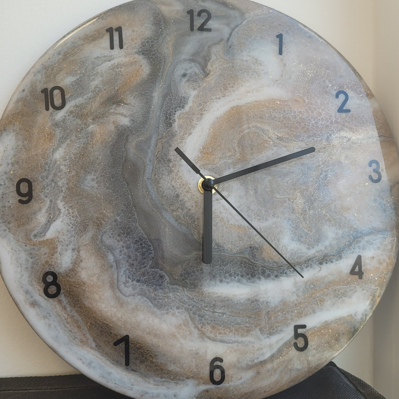 Round wall clock with a marbled design on a plain background