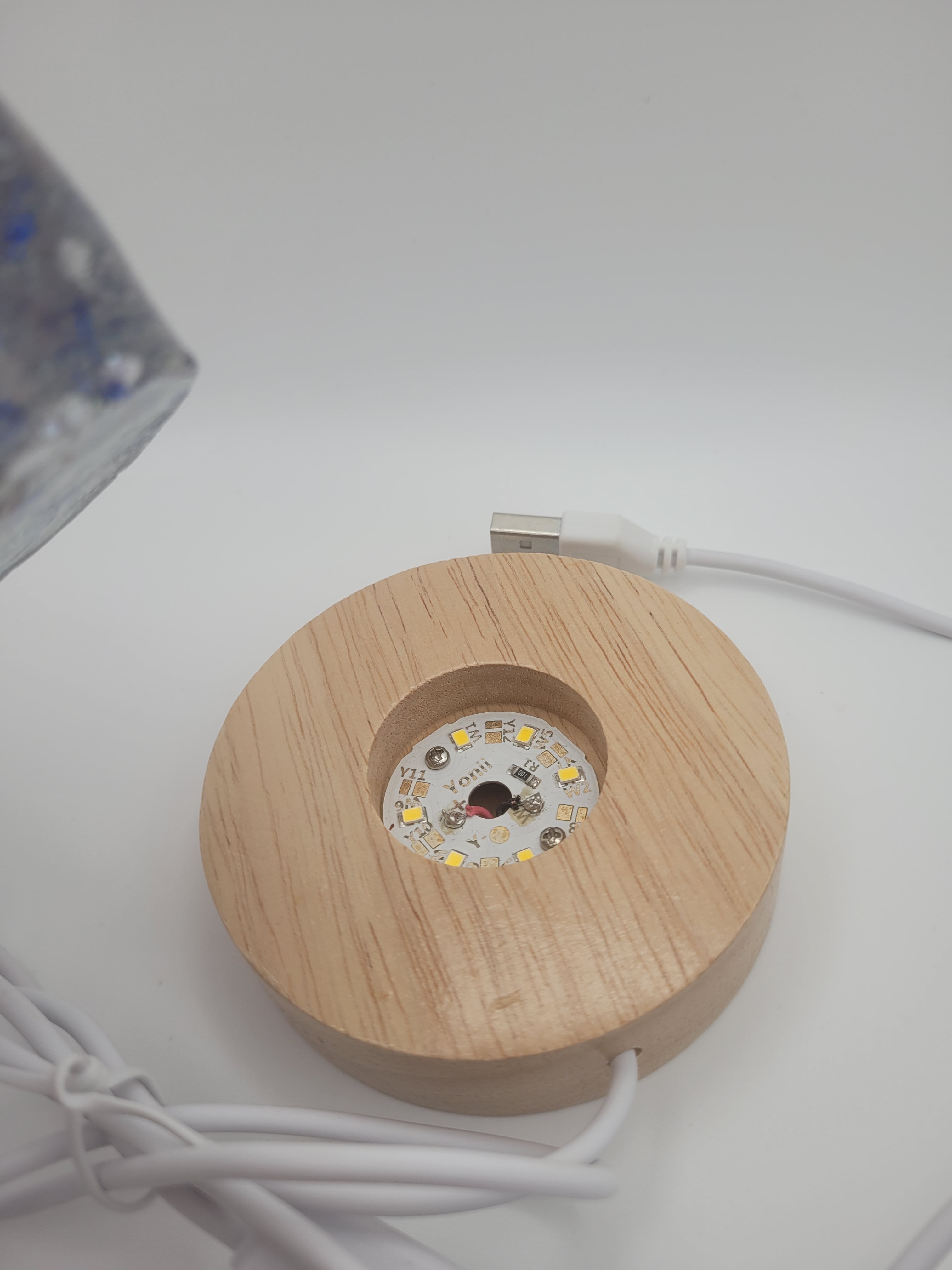 Wooden circular device with electronic components on a white background