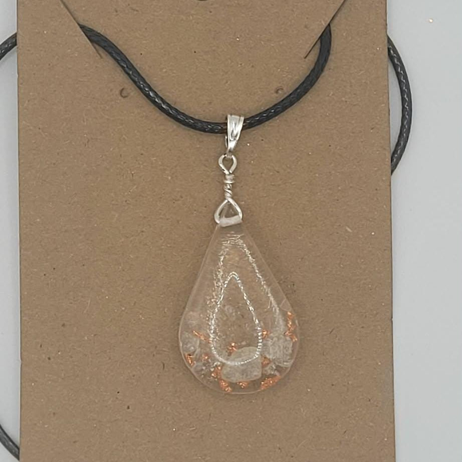 Teardrop-shaped pendant on a black cord with a brown card background